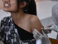 A junior high school student receives an HPV (Human Papillomavirus) vaccine injection from a medical officer in a classroom in Malang, East...