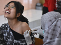 A junior high school student receives an HPV (Human Papillomavirus) vaccine injection from a medical officer in a classroom in Malang, East...