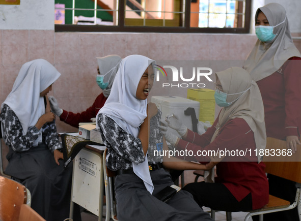 Junior high school students receive the HPV (Human Papillomavirus) vaccine from a medical officer in a classroom in Malang, East Java, Indon...