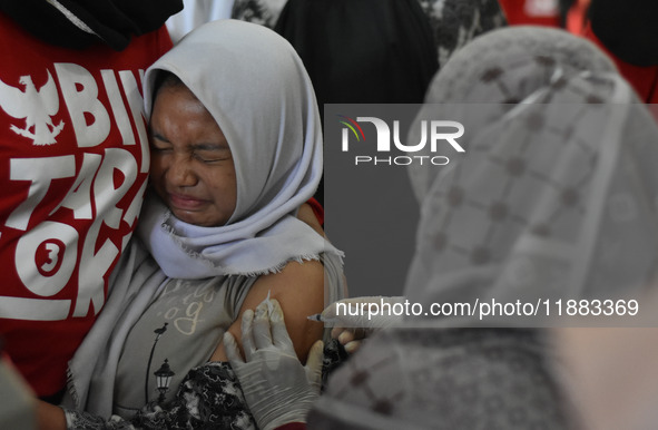 A junior high school student receives an HPV (Human Papillomavirus) vaccine injection from a medical officer in a classroom in Malang, East...