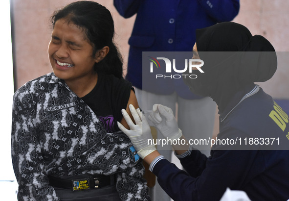 A junior high school student receives an HPV (Human Papillomavirus) vaccine injection from a medical officer in a classroom in Malang, East...