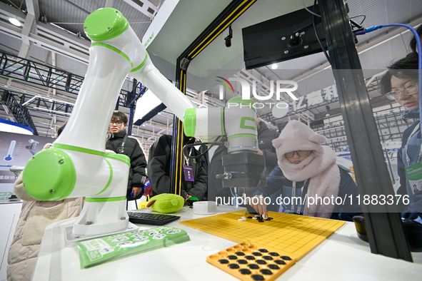 Visitors play gobang with a robot at the World Intelligent Manufacturing Expo 2024 in Nanjing, Jiangsu province, China, on December 20, 2024...