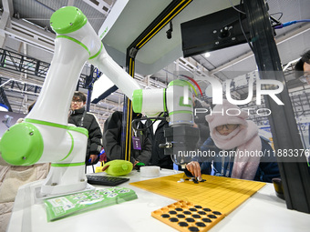 Visitors play gobang with a robot at the World Intelligent Manufacturing Expo 2024 in Nanjing, Jiangsu province, China, on December 20, 2024...