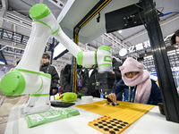 Visitors play gobang with a robot at the World Intelligent Manufacturing Expo 2024 in Nanjing, Jiangsu province, China, on December 20, 2024...