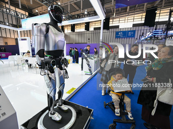 Visitors view a humanoid robot at the World Intelligent Manufacturing Expo 2024 in Nanjing, China, on December 20, 2024. (