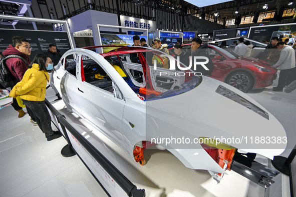 Visitors view a frame-like structure of a Tesla vehicle at the World Intelligent Manufacturing Expo 2024 in Nanjing, China, on December 20,...