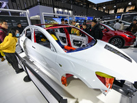 Visitors view a frame-like structure of a Tesla vehicle at the World Intelligent Manufacturing Expo 2024 in Nanjing, China, on December 20,...