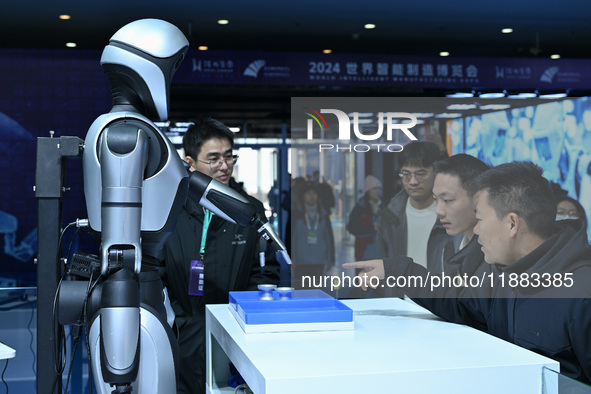 Visitors view a humanoid robot at the World Intelligent Manufacturing Expo 2024 in Nanjing, China, on December 20, 2024. 