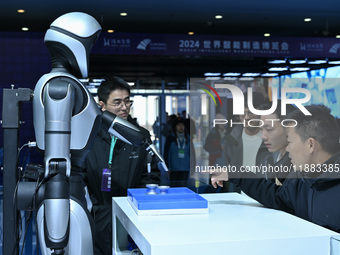 Visitors view a humanoid robot at the World Intelligent Manufacturing Expo 2024 in Nanjing, China, on December 20, 2024. (