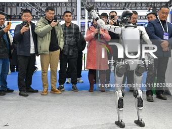 Visitors view a humanoid robot at the World Intelligent Manufacturing Expo 2024 in Nanjing, China, on December 20, 2024. (