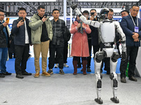 Visitors view a humanoid robot at the World Intelligent Manufacturing Expo 2024 in Nanjing, China, on December 20, 2024. (