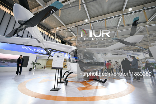 Visitors view electric vertical take-off and landing aircraft at the World Intelligent Manufacturing Expo 2024 in Nanjing, China, on Decembe...