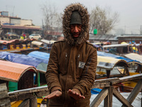 People warm themselves by a bonfire on a cold winter morning at Dal Lake in Srinagar, Jammu and Kashmir, India, on December 20, 2024. Srinag...