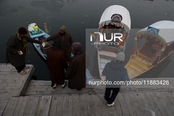 A vendor serves breakfast to tourists in a shikara on a cold winter morning at Dal Lake in Srinagar, Jammu and Kashmir, India, on December 2...