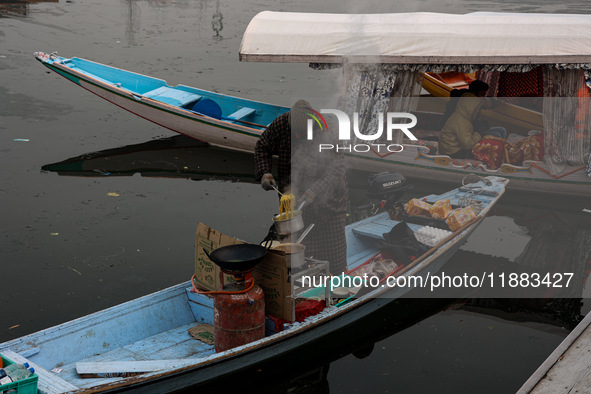 A vendor serves breakfast to tourists in a shikara on a cold winter morning at Dal Lake in Srinagar, Jammu and Kashmir, India, on December 2...