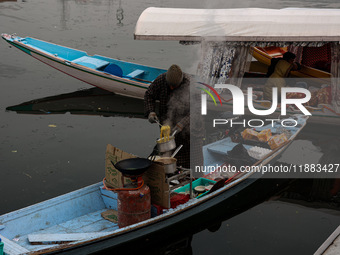 A vendor serves breakfast to tourists in a shikara on a cold winter morning at Dal Lake in Srinagar, Jammu and Kashmir, India, on December 2...