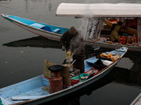 A vendor serves breakfast to tourists in a shikara on a cold winter morning at Dal Lake in Srinagar, Jammu and Kashmir, India, on December 2...