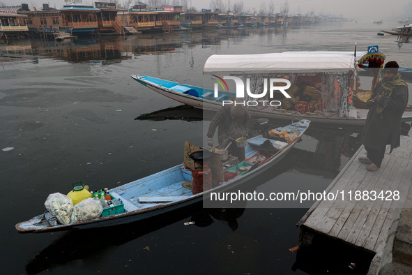 A vendor serves breakfast to tourists in a shikara on a cold winter morning at Dal Lake in Srinagar, Jammu and Kashmir, India, on December 2...