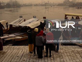 Tourists take a shikara ride on a cold winter morning at Dal Lake in Srinagar, Jammu and Kashmir, India, on December 20, 2024. Srinagar expe...