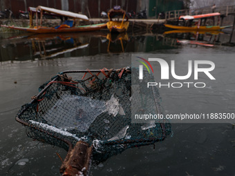 A fisherman shows sheets of ice formed due to cold weather at Dal Lake in Srinagar, Jammu and Kashmir, India, on December 20, 2024. (