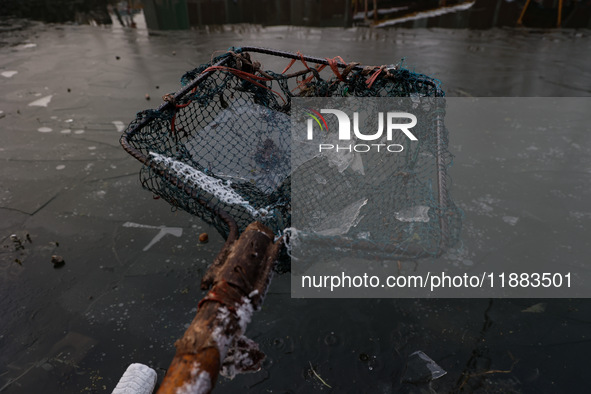 A fisherman shows sheets of ice formed due to cold weather at Dal Lake in Srinagar, Jammu and Kashmir, India, on December 20, 2024. 