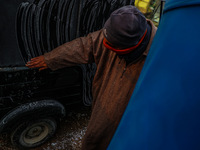 A rickshaw driver clears frost from an auto due to cold weather in Srinagar, Jammu and Kashmir, India, on December 20, 2024. (