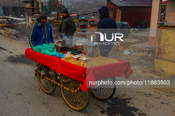 A non-local sells groundnuts and other snacks on a cold winter day in Srinagar, Jammu and Kashmir, India, on December 20, 2024. 