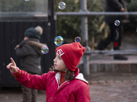 A young Iranian girl plays with soap bubbles in the Abasabad tourism zone in central Tehran, Iran, on December 19, 2024. (