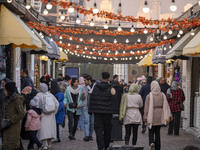 Iranian people walk past food stands while visiting the Abasabad tourism zone in central Tehran, Iran, on December 19, 2024. (