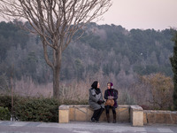 Two Iranian women sit together while visiting the Abasabad tourism zone in central Tehran, Iran, on December 19, 2024. (