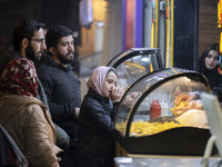 A young Iranian girl waits to receive french fries while visiting the Abasabad tourism zone in central Tehran, Iran, on December 19, 2024. (