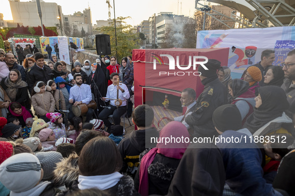 Two street performers perform with an Iranian traditional doll during a festival in the Abasabad tourism zone in central Tehran, Iran, on De...