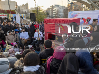 Two street performers perform with an Iranian traditional doll during a festival in the Abasabad tourism zone in central Tehran, Iran, on De...