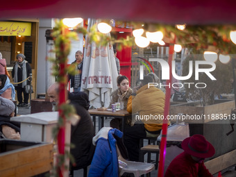 Iranian youths sit together at an outdoor fast-food restaurant while visiting the Abasabad tourism zone in central Tehran, Iran, on December...