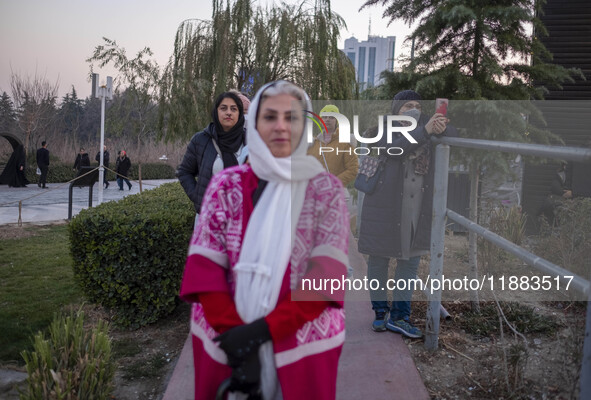 Iranian women stand together while visiting the Abasabad tourism zone during a festival in central Tehran, Iran, on December 19, 2024. 