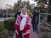 Iranian women stand together while visiting the Abasabad tourism zone during a festival in central Tehran, Iran, on December 19, 2024. (