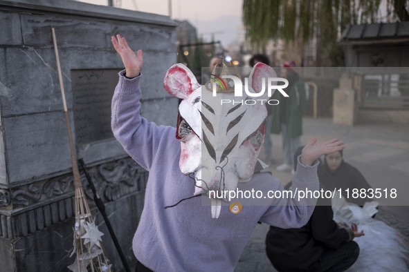 A young Iranian female puppeteer wears a mouse-shaped mask and poses for a photograph while preparing to perform in a festival in the Abasab...