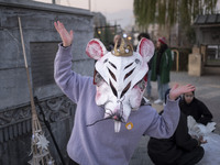 A young Iranian female puppeteer wears a mouse-shaped mask and poses for a photograph while preparing to perform in a festival in the Abasab...