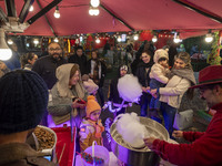 A young Iranian girl receives a traditional sweet while visiting the Abasabad tourism zone with her parents in central Tehran, Iran, on Dece...