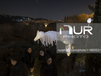 Young Iranian female puppeteers stand next to a puppet, waiting to perform at a festival in the Abasabad tourism zone in central Tehran, Ira...