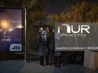 Iranian puppeteers wear mouse-shaped masks and stand together while waiting to perform at a festival in the Abasabad tourism zone in central...