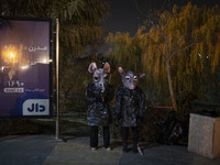 Iranian puppeteers wear mouse-shaped masks and stand together while waiting to perform at a festival in the Abasabad tourism zone in central...