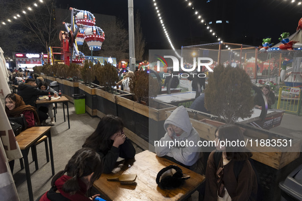 Young Iranian girls sit together at an outdoor fast-food restaurant in the Abasabad tourism zone in central Tehran, Iran, on December 19, 20...