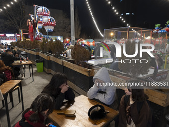 Young Iranian girls sit together at an outdoor fast-food restaurant in the Abasabad tourism zone in central Tehran, Iran, on December 19, 20...