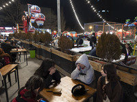 Young Iranian girls sit together at an outdoor fast-food restaurant in the Abasabad tourism zone in central Tehran, Iran, on December 19, 20...