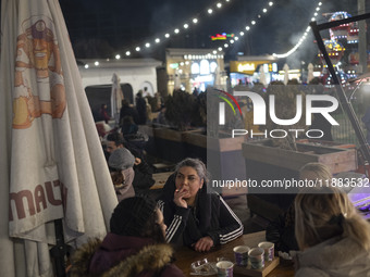 Iranian women sit together at an outdoor fast-food restaurant while visiting the Abasabad tourism zone in central Tehran, Iran, on December...