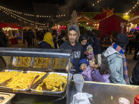 An Iranian family waits to receive french fries while visiting the Abasabad tourism zone in central Tehran, Iran, on December 19, 2024. (