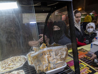 A young Iranian boy waits to receive pizza in the Abasabad tourism zone in central Tehran, Iran, on December 19, 2024. (