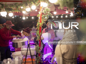 A young Iranian girl waits to receive a traditional sweet while visiting the Abasabad tourism zone with her parents in central Tehran, Iran,...