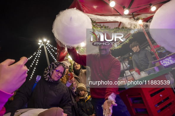 An Iranian vendor prepares a traditional sweet for his clients during a festival in the Abasabad tourism zone in central Tehran, Iran, on De...